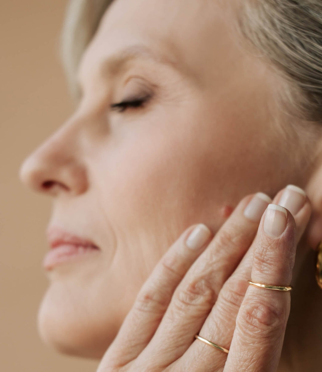 Portrait - seitlich Gesicht reife Frau mit geschlossenen Augen und einer Hand an der Wange