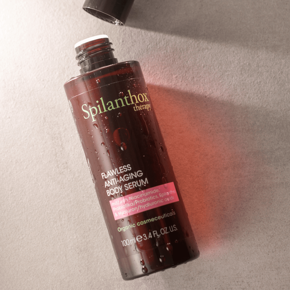 Flawless Anti-Aging Body Serum geöffent mit Wassertropfen